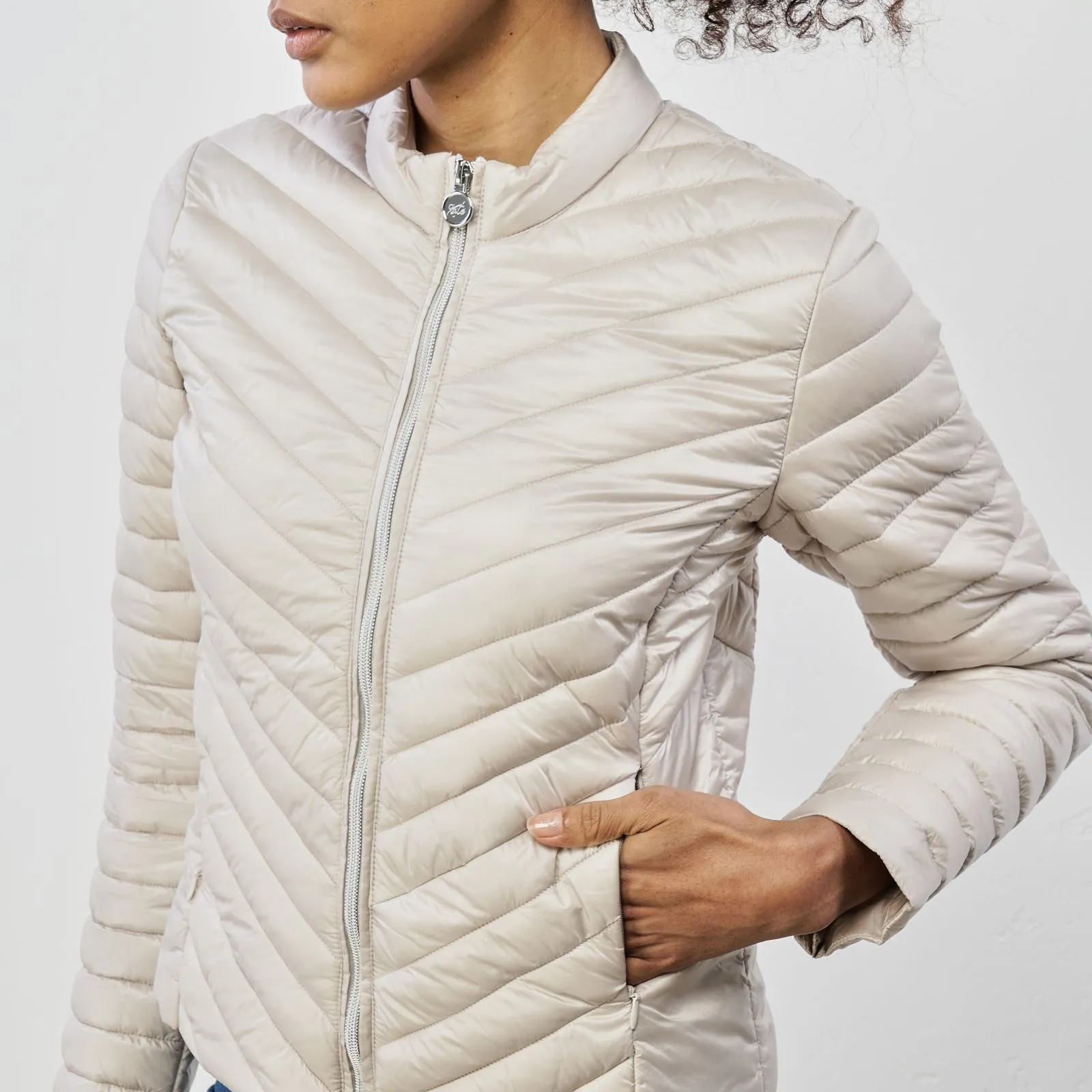 Piumino leggero beige con zip e tasche